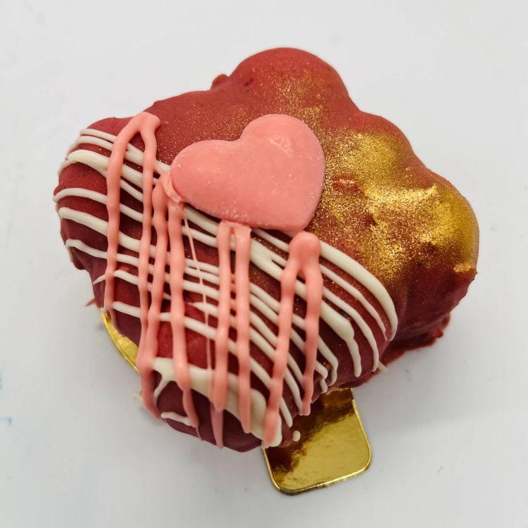 Pastel de chocolate rosa y rojo con un corazón 