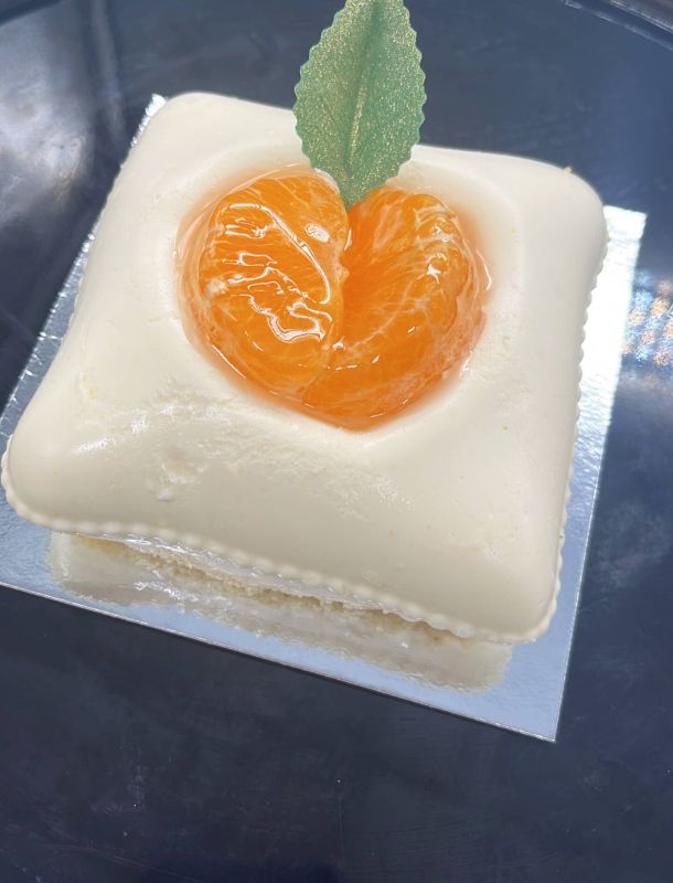 Imagen de pastel con forma cuadrada blanca y naranja dentro brillante
